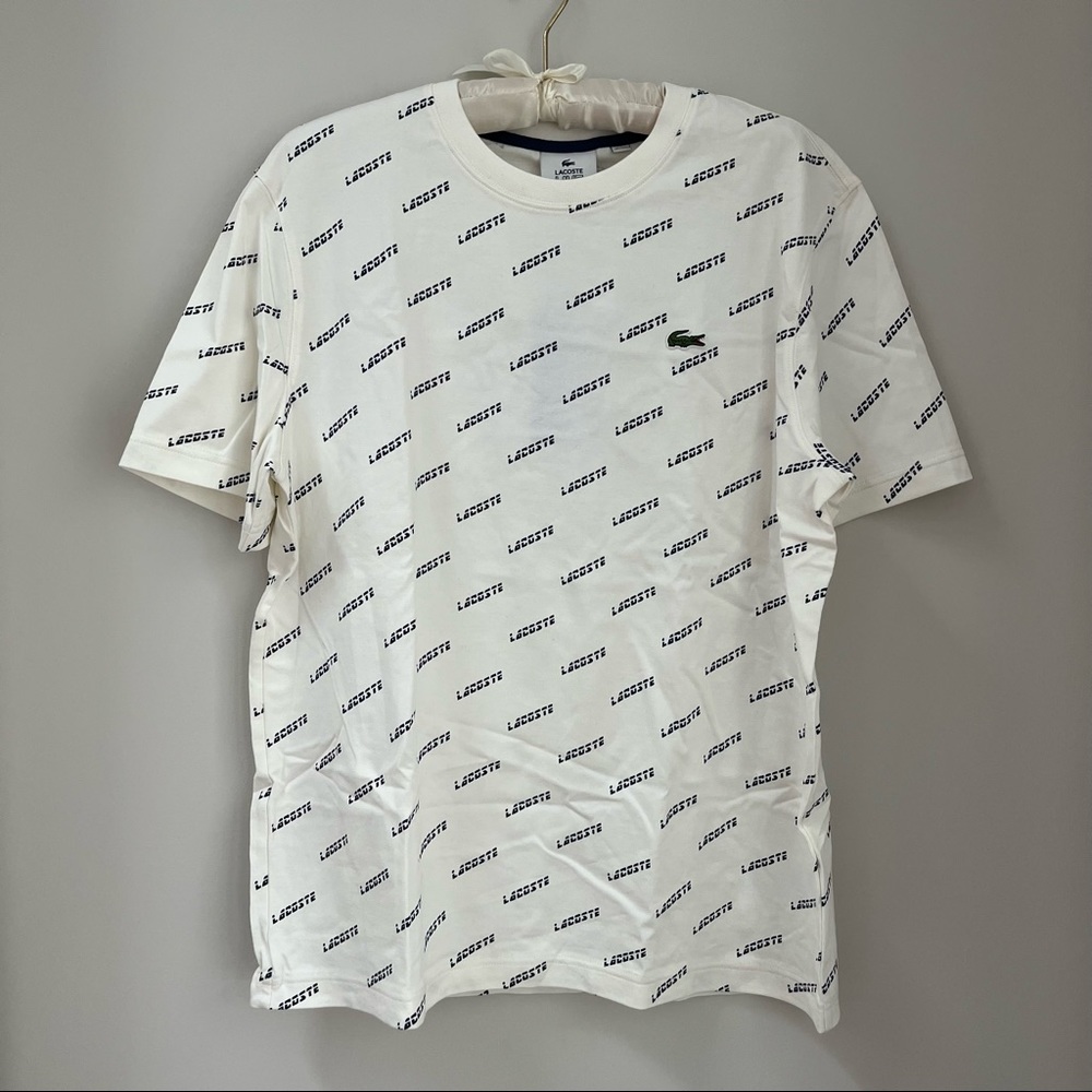 Never worn Lacoste tee with Lacoste logo navy pattern.